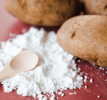 Potato resistant starch powder next to potatoes